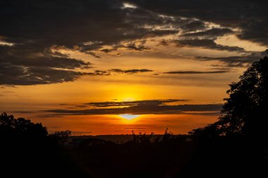 Yoğun turuncu ışıklar ve huzurlu dramatik manzaralı dramatik bir gün doğumu.