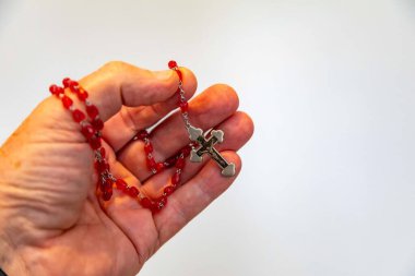 Kırmızı yakut boncuklu Katolik tespihinin yaratıcı fotoğrafı.