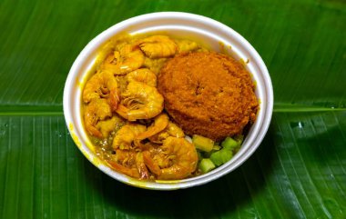 Authentic Brazilian acaraj prepared with dumplings, vatap, caruru, dried shrimp, salad and fried in palm oil. Served on a banana leaf clipart