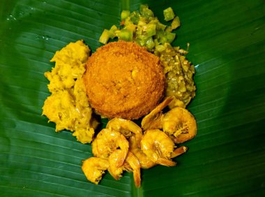 Authentic Brazilian acaraj prepared with dumplings, vatap, caruru, dried shrimp, salad and fried in palm oil. Served on a banana leaf clipart