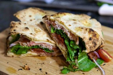 Geleneksel İtalyan Napolitan panuozzo, zanaatkar pizza hamuru, roka ve güneşte kurutulmuş domateslerle hazırlandı.