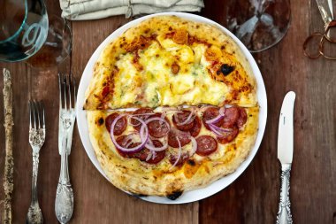 En otantik Brezilya pizzası, yarım sucuklu, soğanlı ve dört peynirli.