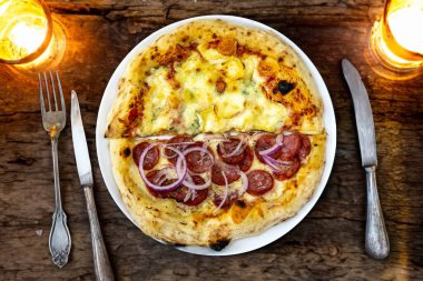 En otantik Brezilya pizzası, yarım sucuklu, soğanlı ve dört peynirli.
