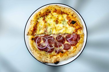 En otantik Brezilya pizzası, yarım sucuklu, soğanlı ve dört peynirli.
