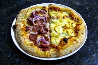 En otantik Brezilya pizzası, yarım sucuklu, soğanlı ve dört peynirli.