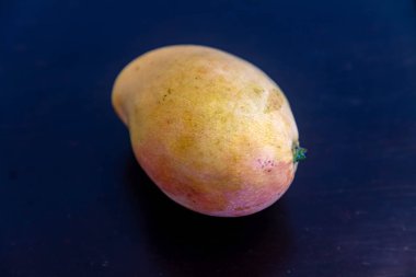 Üniformalı arka planda izole edilmiş olgun Rosa Mango. Brezilya meyvesi ve yiyeceği