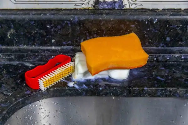 Çamaşır lavabosunun, süngerin, sabunun ve temizlik fırçasının detayları.