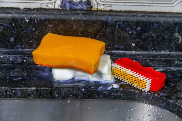 Çamaşır lavabosunun, süngerin, sabunun ve temizlik fırçasının detayları.