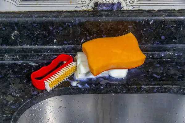 Çamaşır lavabosunun, süngerin, sabunun ve temizlik fırçasının detayları.