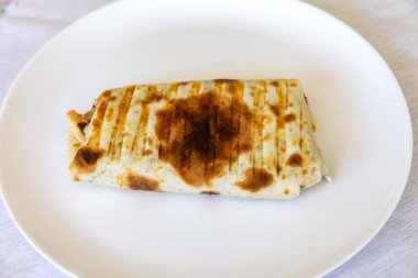 Nefis bir shawarma dürümünün yakın çekimi.