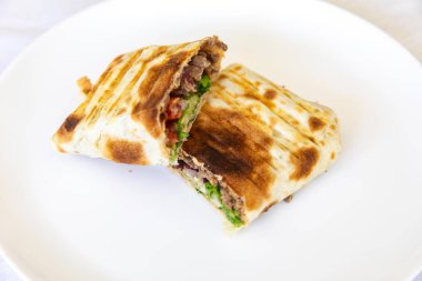 Nefis bir shawarma dürümünün yakın çekimi.