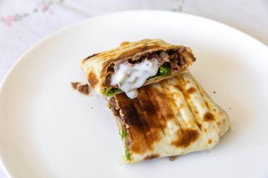 Nefis bir shawarma dürümünün yakın çekimi.
