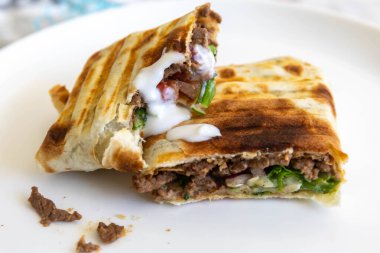 Nefis bir shawarma dürümünün yakın çekimi.