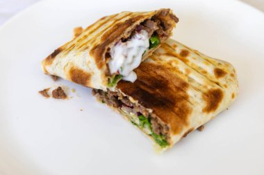Nefis bir shawarma dürümünün yakın çekimi.