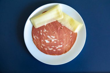 Beyaz bir tabakta dilimlenmiş bir sucuğun yakın çekimi.