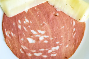 Beyaz bir tabakta dilimlenmiş bir sucuğun yakın çekimi.