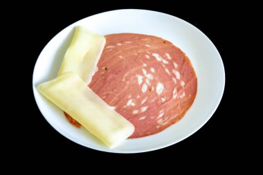 Beyaz bir tabakta dilimlenmiş bir sucuğun yakın çekimi.