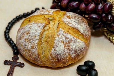 Köy ekmeği, zeytinyağı, şarap, üzüm, tespih ve buğday kulaklı Katolik kutsal masası. İsa 'nın bedeni ve kanı