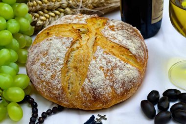 Köy ekmeği, zeytinyağı, şarap, üzüm, tespih ve buğday kulaklı Katolik kutsal masası. İsa 'nın bedeni ve kanı