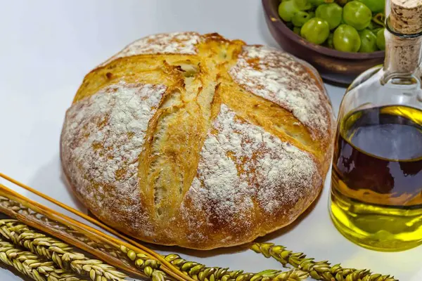 Köy ekmeği, zeytinyağı, şarap, üzüm, tespih ve buğday kulaklı Katolik kutsal masası. İsa 'nın bedeni ve kanı
