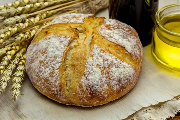 Köy ekmeği, zeytinyağı, şarap, üzüm, tespih ve buğday kulaklı Katolik kutsal masası. İsa 'nın bedeni ve kanı