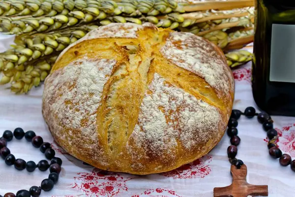 Köy ekmeği, zeytinyağı, şarap, üzüm, tespih ve buğday kulaklı Katolik kutsal masası. İsa 'nın bedeni ve kanı