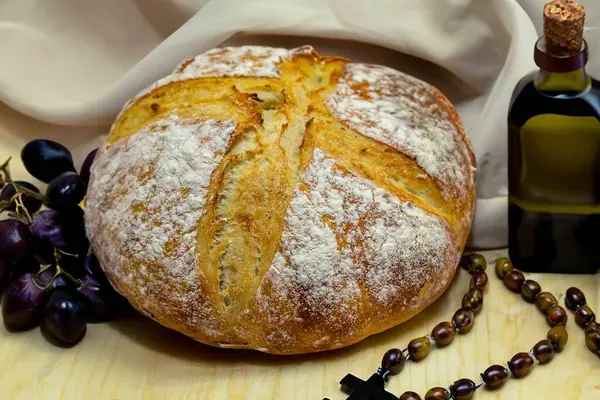 Köy ekmeği, zeytinyağı, şarap, üzüm, tespih ve buğday kulaklı Katolik kutsal masası. İsa 'nın bedeni ve kanı
