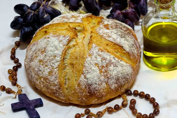 Köy ekmeği, zeytinyağı, şarap, üzüm, tespih ve buğday kulaklı Katolik kutsal masası. İsa 'nın bedeni ve kanı