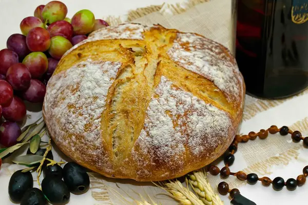 Köy ekmeği, zeytinyağı, şarap, üzüm, tespih ve buğday kulaklı Katolik kutsal masası. İsa 'nın bedeni ve kanı