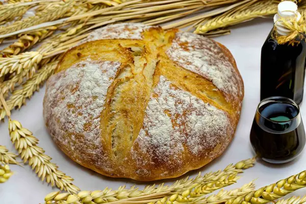 Köy ekmeği, zeytinyağı, şarap, üzüm, tespih ve buğday kulaklı Katolik kutsal masası. İsa 'nın bedeni ve kanı