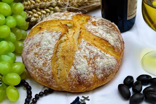 Köy ekmeği, zeytinyağı, şarap, üzüm, tespih ve buğday kulaklı Katolik kutsal masası. İsa 'nın bedeni ve kanı