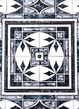 Geometrik desenli ve dekoratif elementlere sahip detaylı bir mermer mozaiğin yakın çekimi