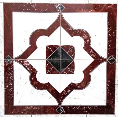 Geometrik desenli ve dekoratif elementlere sahip detaylı bir mermer mozaiğin yakın çekimi