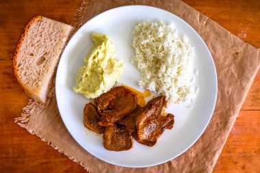 Klasik kırsal Brezilya yemeği, pirinçli sığır dili ve patates püresi. Gerçek yemek.