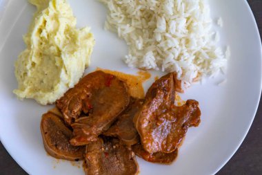 Klasik kırsal Brezilya yemeği, pirinçli sığır dili ve patates püresi. Gerçek yemek.