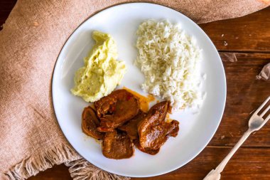 Klasik kırsal Brezilya yemeği, pirinçli sığır dili ve patates püresi. Gerçek yemek.