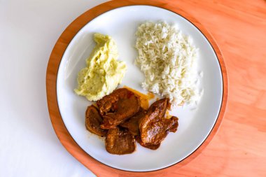 Klasik kırsal Brezilya yemeği, pirinçli sığır dili ve patates püresi. Gerçek yemek.