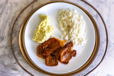 Klasik kırsal Brezilya yemeği, pirinçli sığır dili ve patates püresi. Gerçek yemek.