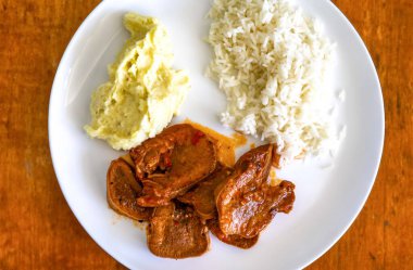 Klasik kırsal Brezilya yemeği, pirinçli sığır dili ve patates püresi. Gerçek yemek.