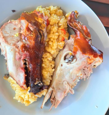 Kızarmış domuz kafası beyaz bir tabakta yarıya bölünür. Dünyanın en egzotik ve kırsal yiyeceği, pişmiş domuz kafası.