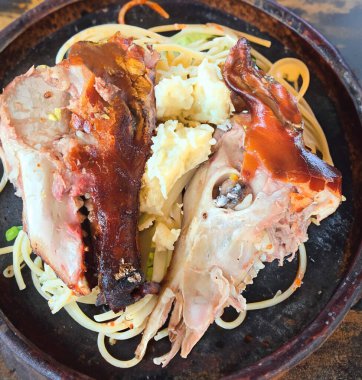 Kızarmış domuz kafası beyaz bir tabakta yarıya bölünür. Dünyanın en egzotik ve kırsal yiyeceği, pişmiş domuz kafası.