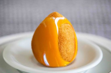 Aşkın ikonik çileğinden esinlenerek karamel kabuklu Coxinha do amor.