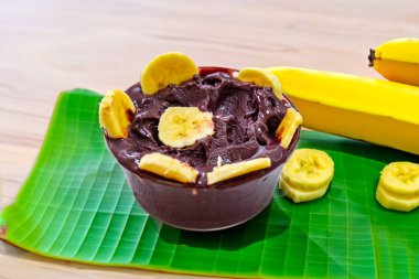 En otantik Brezilya aa 'sı, Euterpe oleracea, minimalist bir kasede muz ve uyumlu bir ortam. Süper gıda enerjisi ve vitaminler