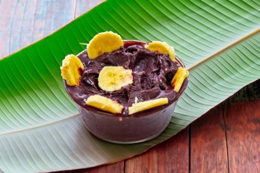 En otantik Brezilya aa 'sı, Euterpe oleracea, minimalist bir kasede muz ve uyumlu bir ortam. Süper gıda enerjisi ve vitaminler