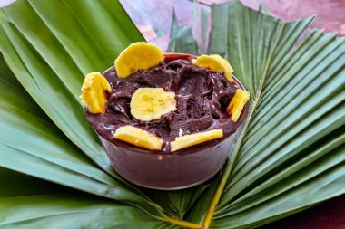 En otantik Brezilya aa 'sı, Euterpe oleracea, minimalist bir kasede muz ve uyumlu bir ortam. Süper gıda enerjisi ve vitaminler