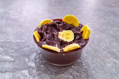 En otantik Brezilya aa 'sı, Euterpe oleracea, minimalist bir kasede muz ve uyumlu bir ortam. Süper gıda enerjisi ve vitaminler