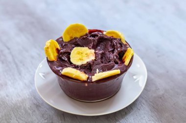 En otantik Brezilya aa 'sı, Euterpe oleracea, minimalist bir kasede muz ve uyumlu bir ortam. Süper gıda enerjisi ve vitaminler