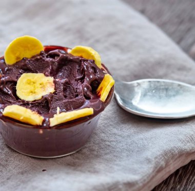 En otantik Brezilya aa 'sı, Euterpe oleracea, minimalist bir kasede muz ve uyumlu bir ortam. Süper gıda enerjisi ve vitaminler