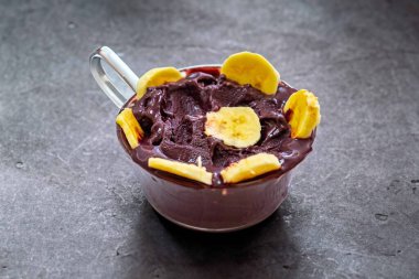 En otantik Brezilya aa 'sı, Euterpe oleracea, minimalist bir kasede muz ve uyumlu bir ortam. Süper gıda enerjisi ve vitaminler