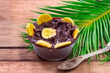 En otantik Brezilya aa 'sı, Euterpe oleracea, minimalist bir kasede muz ve uyumlu bir ortam. Süper gıda enerjisi ve vitaminler